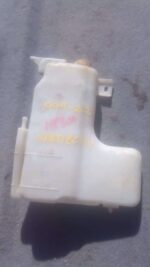 Front view of a used washer bottle for a Nissan Hardbody, showing overall shape and connector details.Front vi