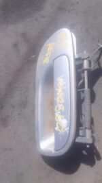 Right rear outer door handle for Volvo S60 displayed close-up, showing used metal part and mounting points.Rig