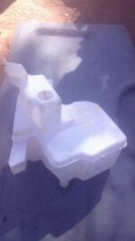 Front view of a used windshield washer bottle for 2016 Toyota GT, showing cap and fluid reservoir.Front view o