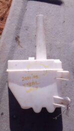 Front view of a used Nissan X-Trail windshield washer bottle with attached hose and cap.Front view of a used N