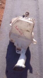 Front view of a used washer bottle for a compact car, showing cap and fluid reservoir.Front view of a used was