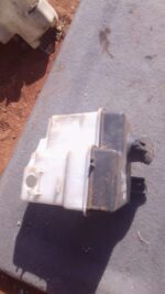 Front view of used Hyundai Getz washer bottle showing cap and spout, angled slightly to the left.Front view of