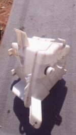 Front view of a used windshield washer bottle for Toyota Corolla, showing mounting points and cap.Front view o