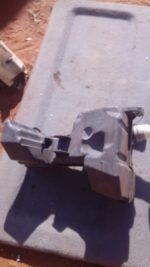 Front view of a used VW Golf 7 windshield washer bottle with attached hoses and cap.Front view of a used VW Go