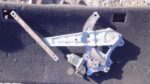 Used right rear window regulator mechanism for Nissan Tiida, viewed from side angle.Used right rear window reg