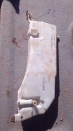 Front angle view of a used car washer bottle for an Infinity G35, showing mounting points and fluid cap.Front