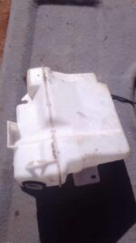 Front view of a used washer bottle for a 2011 Mitsubishi Lancer showing bottle and attached hose.Front view of