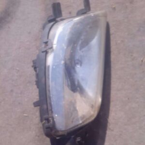 Left front headlight for Peugeot 308 viewed from the front left, used condition, showing clear lens and connec