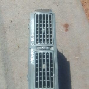 Front view of a used Daewoo Celo center dash air vent showing horizontal slats and mounting points.Front view