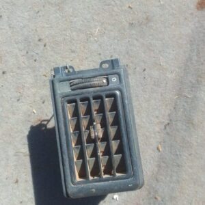 Front view of used Opel Kadett dashboard air vent with control knob and surrounding black trim.Front view of u