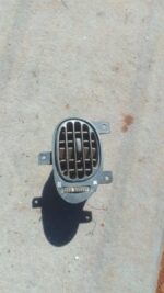 Front view of a used Hyundai Elantra dashboard air vent assembly with control knob and vent fins.Front view of