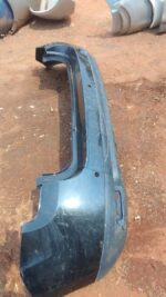 Rear bumper of a 2012 Renault Duster, used condition, shown from a slightly angled rear view.Rear bumper of a