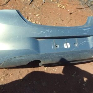 Rear view of a used Opel Corsa rear bumper, showing the full curved exterior panel positioned horizontally.Rea
