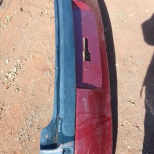Rear view of a used grey car rear bumper for an Opel Corsa Gamma, slightly curved and intact.Rear view of a us