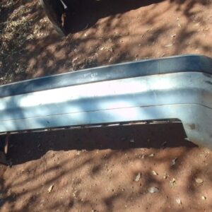Rear angle view of a used black rear bumper for BMW E36, showing mounting points and contours.Rear angle view