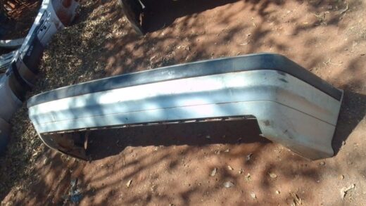 1998 Bmw E36 Rear Bumper - Used Rear angle view of a used black rear bumper for BMW E36, showing mounting points and contours.Rear angle view