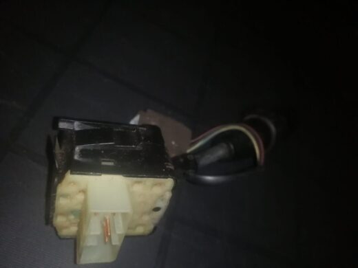 A close-up image of an electrical connector block, featuring a yellow plastic base with two copper terminals visible, and several colored wires attached, set against a dark background.